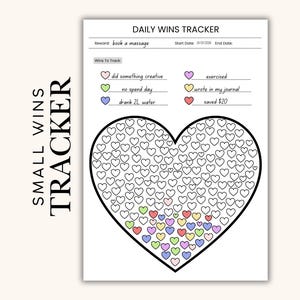 Op de afbeelding: Een witte Daily Wins Tracker met de tekst "SMALL WINS TRACKER". De tracker bevat een hartvormige afbeelding gevuld met kleine hartjes en een lijst met overwinningen om bij te houden, zoals "did something creative" en "exercised".