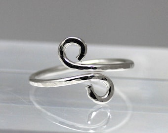 Può includere: Un anello d'argento con finitura martellata e un design unico a doppio anello.