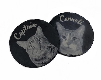 Puede incluir: Dos posavasos de pizarra negra con imágenes grabadas de gatos y sus nombres, "Captain" y "Cannoli".