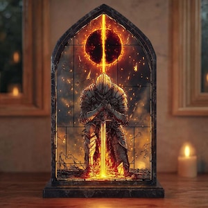 May include: A stained glass panel featuring a kneeling knight in full armor, holding a glowing sword. Above the knight is a fiery sunburst design. The panel is set in a dark, arched frame, with a stone base.