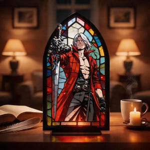 May include: A stained glass panel depicting a character in a red coat holding a sword. The panel is set in a black frame. A lit candle, a cup of coffee, and an open book with a feather are on the table.