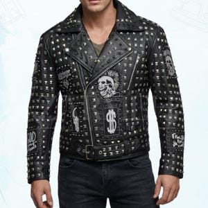 May include: Black leather jacket with silver studs and patches. Features a classic biker style with a notched collar, asymmetrical zipper, and a buckled belt. Patches include skull and dollar sign graphics.