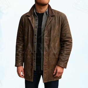 Puede incluir: Chaqueta de cuero marrón con botones y cuello. La chaqueta tiene un aspecto desgastado y un diseño clásico de abrigo largo. El modelo lleva una camisa negra y vaqueros azules.