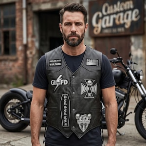May include: A black leather vest featuring multiple patches, including text reading Black Label Society Worldwide, HLS, GDFD, Doom Crew Inc, and Berserker. The vest has a V-neck, snap button closures, and side lacing details over a plain black t-shirt.