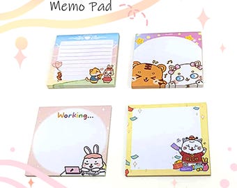 May include: Four square memo pads with colorful designs. Each pad features a different illustration of cartoon animals, including a tiger, cat, rabbit, and bear. The pads have a white space for writing and the text "Memo Pad" is visible.