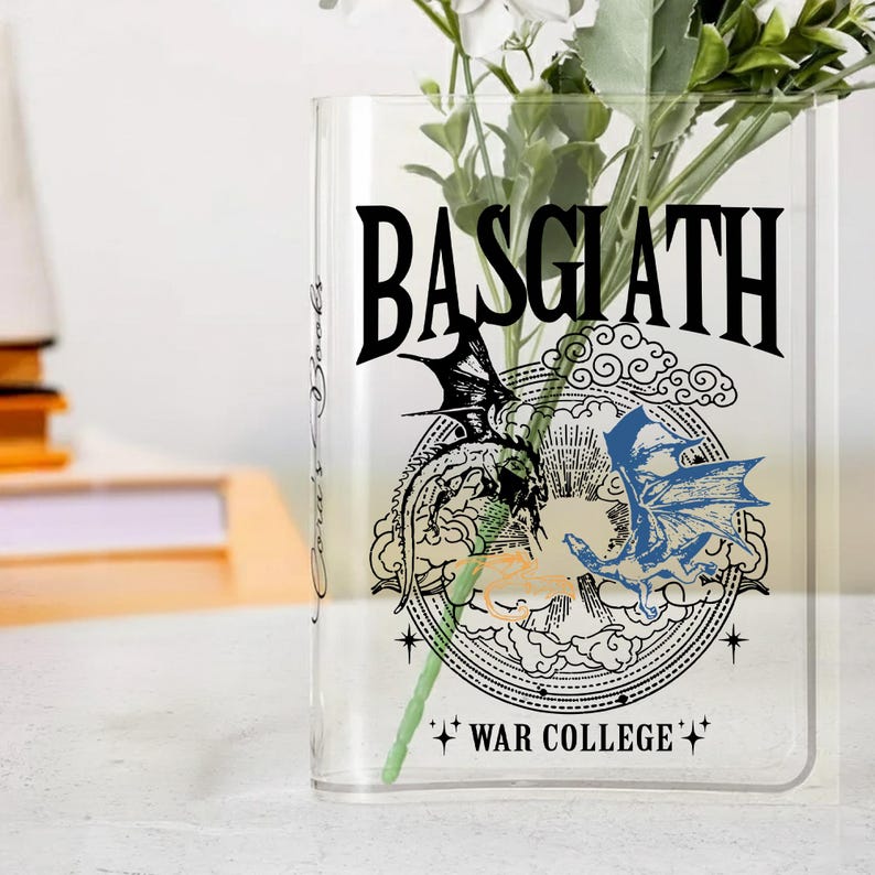 May include: A clear glass vase with the word "BASGIATH" in large black letters. Below the text is a circular design with two dragons, one black and one blue. The words "WAR COLLEGE" are at the bottom.