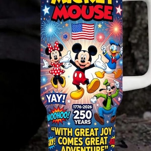 May include: A white-handled tumbler featuring Mickey Mouse and friends against a dark blue background with fireworks and stars. The tumbler celebrates 250 years with the text "Mickey Mouse" and "With great joy comes great adventure."