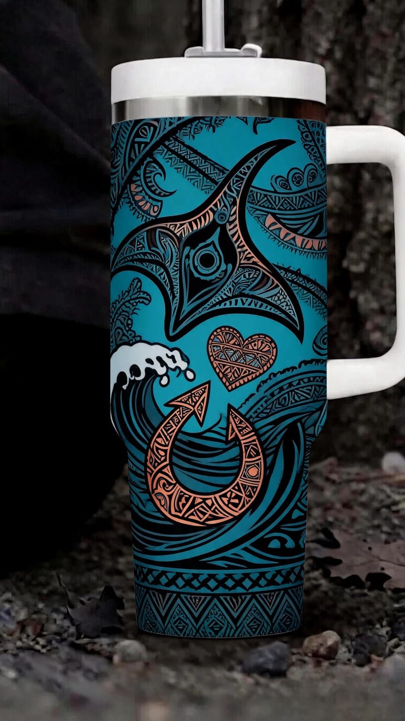May include: A teal travel mug with a white handle and lid. The mug features a detailed design of a manta ray, waves, and other Polynesian-inspired symbols in black and orange. The background is a teal colour.