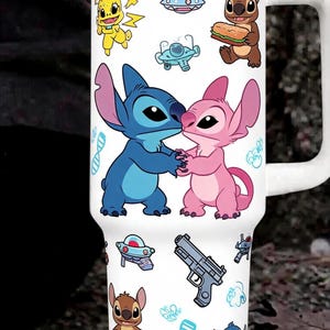 May include: A white stainless steel tumbler with a handle and lid, featuring a repeating pattern of blue and pink alien characters, a yellow creature, a grey handgun, blue DNA strands, small spaceships, and various small blue graphic icons.