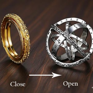 Puede incluir: Un anillo dorado con intrincados diseños junto a un anillo esférico plateado calado. El anillo esférico tiene letras y números grabados. La imagen muestra el anillo en posición cerrada y abierta, con las palabras "Close" y "Open" debajo.