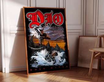 May include: A framed poster featuring the band Dio's "Holy Diver" album art. The artwork depicts a demon figure chained underwater, with the band's logo in red above. The poster is in a wooden frame and leans against a wall.