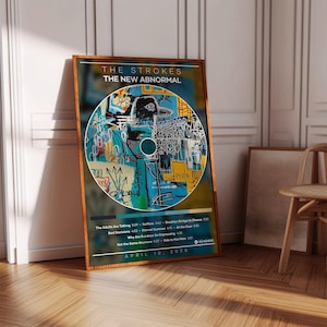 May include: A framed poster of The Strokes' album "The New Abnormal." The artwork is a vibrant, abstract design in blue, yellow, and white. The poster displays the album title, band name, and tracklist, with the date April 10, 2020.