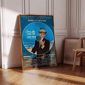 May include: A framed poster featuring Frank Sinatra's "Come Fly With Me" album cover. The poster has a blue background with Sinatra in a suit and hat. The album title and song list are displayed.