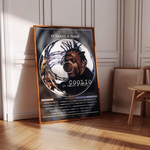 May include: A framed poster featuring the album cover for Coolio's "It Takes a Thief." The artwork showcases a circular design with Coolio's image and album details. The poster is in a wooden frame, displayed against a wall.