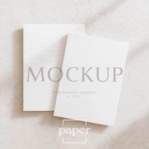 Puede incluir: Dos maquetas rectangulares blancas con la palabra "MOCKUP" en fuente morada clara. El texto "PSD SMART OBJECT + JPG" está debajo de la palabra "MOCKUP". El logotipo "paper is mind" está en la parte inferior.