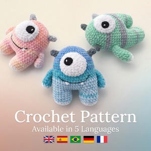 Puede incluir: Tres juguetes de monstruos de ganchillo en rosa, azul y verde. Cada uno tiene un ojo grande y blanco y pequeñas cuernos. El texto "Crochet Pattern" y "Available in 5 Languages" se muestra debajo, junto con banderas.