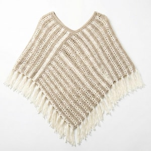 Puede incluir: Un poncho de crochet beige y crema con cuello en V y flecos. El poncho presenta rayas beige y crema alternas, con flecos crema en el borde inferior. La prenda se muestra sobre un fondo blanco. Mide aproximadamente 76 cm de ancho.