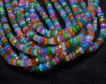May include: A collection of colorful opal gemstone beads. The beads are a mix of orange, green, blue, purple, and pink. The beads are strung together, creating a vibrant and eye-catching display. The beads are small and round.