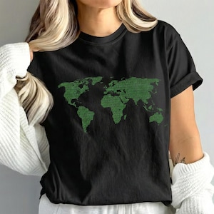 May include: Black t-shirt featuring a green world map design. The map is composed of a matrix of green text, creating a unique visual effect. The shirt has short sleeves and a crew neck.