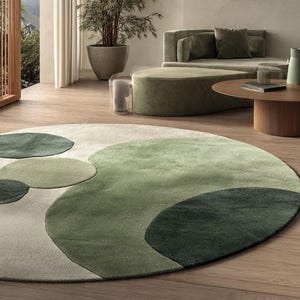 May include: An interior scene with a green and white abstract rug, a green sofa, and a round coffee table. A large potted plant and a window with a mountain view are also visible.