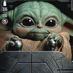 May include: A detailed 1/6 scale resin figure of a green-skinned alien with large black eyes, wearing a tan robe, and holding two silver spheres. The figure is set in a dark gray, textured environment. The figure is from the Star Wars universe.
