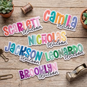 May include: Six embroidered name patches featuring the names Scarlett, Camila, Nicholas, Jackson, Leonardo, and Brooklyn, each paired with the cursive surname Wilson. The letters are multi-colored with a white border and a stitched texture.