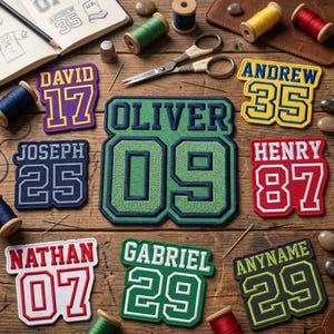 May include: Assortment of embroidered name and number patches in various colors, including purple, green, red, and yellow. The patches are displayed on a wooden surface with sewing supplies like thread spools, scissors, and a thimble.