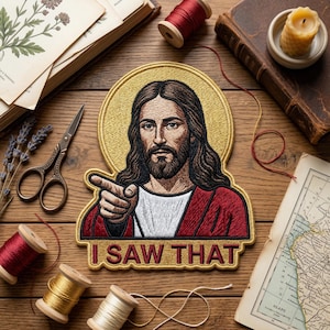 May include: Embroidered patch featuring a portrait of Jesus with a gold halo, pointing. The text "I SAW THAT" is below the image. The patch is surrounded by sewing supplies, books, and a candle.