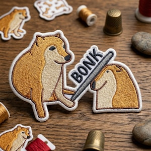 May include: Embroidered patches featuring a Shiba Inu dog meme. One patch shows the dog with the word "BONK" and a bat. Other patches show the dog in different poses. The patches are in shades of brown, beige, and white.