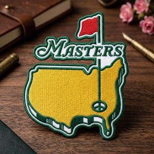 May include: Embroidered patch featuring the word "Masters" in a green and white script, with a red flag and a golf course map design in yellow and green. The patch has a white border and a peace sign.