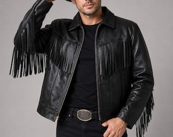 May include: A black leather jacket featuring long fringe detailing across the chest and down the sleeves, paired with a black cowboy hat, a black t-shirt, black jeans, and a metallic belt buckle with an intricate embossed floral pattern.