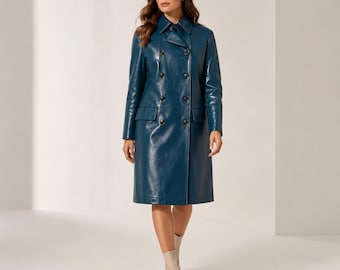 May include: A knee-length, double-breasted coat in a deep teal blue color with a smooth, polished finish. The coat features a classic collar, long sleeves, two side flap pockets, and a row of dark buttons down the front center.