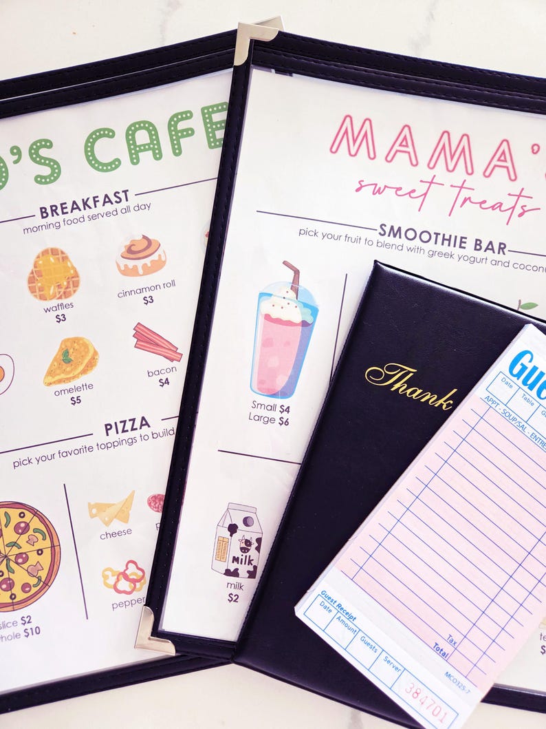 K&ouml;nnte beinhalten: Caf&eacute;-Men&uuml; mit Fr&uuml;hst&uuml;cks-, Pizza- und Smoothie-Optionen. Das Men&uuml; befindet sich in einem schwarzen, ledergebundenen Einband. Ein G&auml;stebon und ein schwarzer Rechnungsordner mit dem Wort "Danke" sind ebenfalls zu sehen.