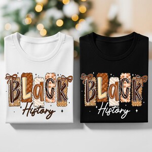 May include: Two t-shirts, one white and one black, with the words "Black History" printed on them. The text is in a decorative font with brown, beige, and cream colors, and a bow design.