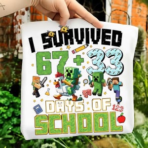 May include: White tote bag with the text "I Survived 67 + 33 Days of School" in black and green. The design includes pixelated characters, bees, stars, a pencil, an apple, and a notebook.