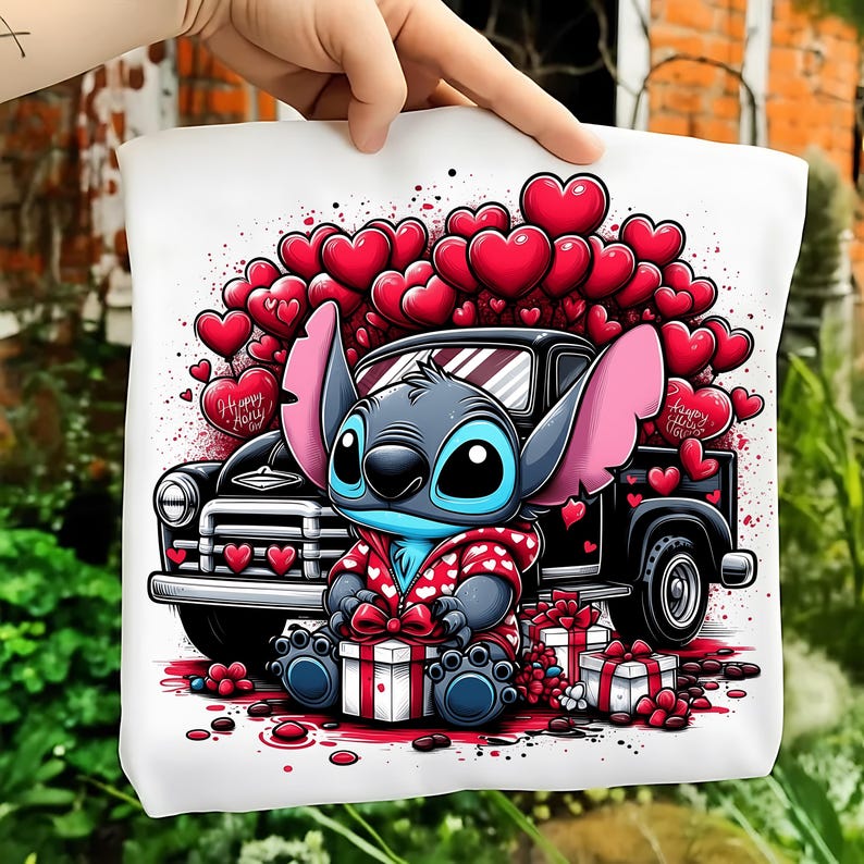 May include: White tote bag featuring a cartoon character with large ears, blue skin, and a red jacket, sitting in front of a black truck filled with red hearts. The bag has the text "Happy Holy" on a heart.