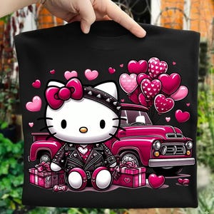 Puede incluir: Camiseta negra con una imagen de dibujos animados de Hello Kitty con una chaqueta de cuero con tachuelas y un lazo, rodeada de corazones y regalos rosas. Un cami&oacute;n rosa con globos en forma de coraz&oacute;n completa el dise&ntilde;o de San Valent&iacute;n.
