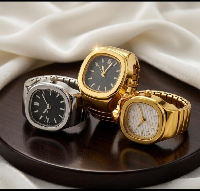 May include: Three ring watches with square faces are displayed. One is silver with a black face, and two are gold, one with a black face and the other with a white face. The watches have a classic design.