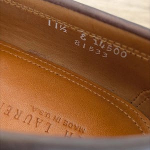May include: Close-up of a brown leather shoe interior. The insole is a light brown color with the text "MADE IN U.S.A." stamped on it. The shoe size is 11 1/2, with other numbers visible.