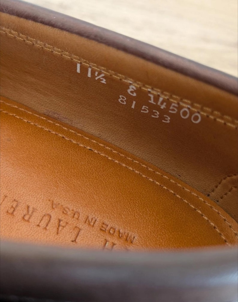 May include: Close-up of a brown leather shoe interior. The insole is a light brown color with the text "MADE IN U.S.A." stamped on it. The shoe size is 11 1/2, with other numbers visible.