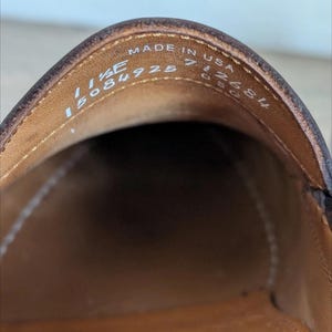 May include: Close-up of the interior of a brown leather shoe. The shoe's insole is a lighter brown color. The text "MADE IN USA" is visible, along with size and style information.