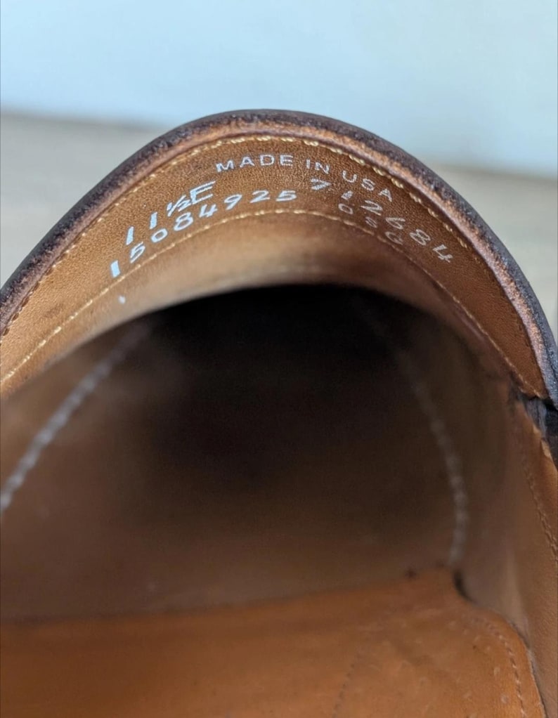 May include: Close-up of the interior of a brown leather shoe. The shoe's insole is a lighter brown color. The text "MADE IN USA" is visible, along with size and style information.