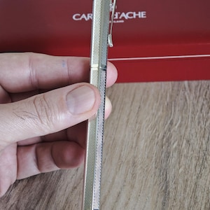 May include: A set of three ceramic mugs with a speckled, matte finish. The mugs are in shades of cream, light gray, and dark gray. Each mug has a simple, minimalist design and a rounded handle. The mugs are likely for coffee or tea.