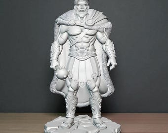 Puede incluir: Una detallada figura gris impresa en 3D de un guerrero musculoso y barbudo. La figura lleva una capa forrada de piel, una armadura ornamentada y una prenda similar a una falda. Sostiene una maza y está sobre una base rocosa.
