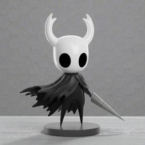 May include: A white and black figurine of a character with large horns, a cape, and a sword. The figure stands on a gray circular base. The character has large black eyes and a stylized design.