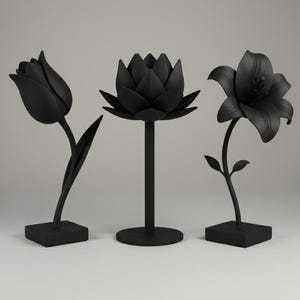 May include: Three black metal flower sculptures: a tulip, a lotus, and a lily. The tulip and lily are on square bases, while the lotus is on a round base. Each sculpture has a stem and detailed petals.