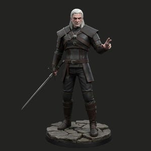 Op de afbeelding: Gedetailleerd beeldje van een personage uit de serie The Witcher. De figuur is gekleed in donkere bepantsering, houdt een zwaard vast en staat op een stenen basis. Het personage heeft wit haar en een strenge uitdrukking.