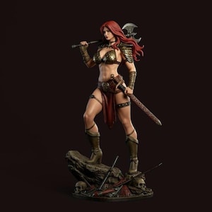Puede incluir: Figura detallada de una mujer guerrera con cabello rojo, vestida con armadura de bronce y una falda roja. Sostiene un hacha sobre su hombro y una espada a su lado, de pie sobre una roca con calaveras y armas a sus pies.