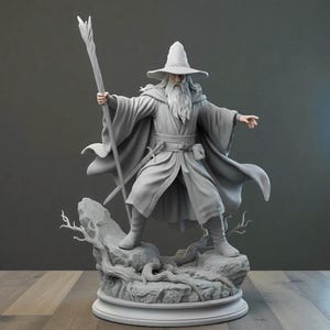 Pode incluir: Estatueta cinzenta detalhada de um mago, segurando uma bengala e em pé sobre uma base rochosa. O mago usa uma longa túnica, um chapéu de abas largas e tem uma longa barba. A estatueta é um item colecionável com tema de fantasia.