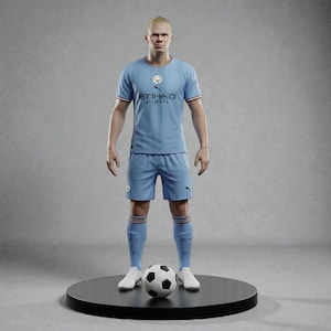 Op de afbeelding: Een lichtblauw voetbaltenue met rode rand, met het Etihad Airways-logo. Het tenue bestaat uit een shirt, een korte broek en sokken, gedragen met witte schoenen. Een zwart-witte voetbal ligt aan de voeten van de figuur. De figuur staat op een zwarte, cirkelvormige basis.